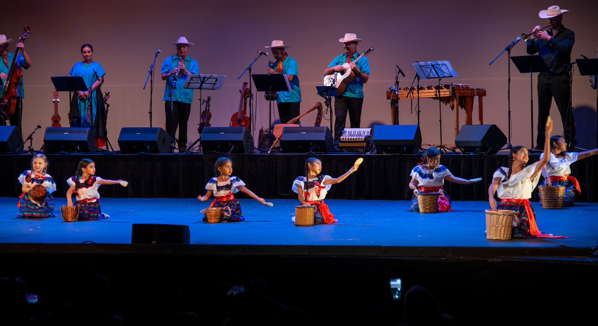 Children performing a Mexican folk dance handing out tortillas to an imaginary customer.